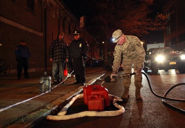 A National Guardsman fills gas for a person in Brooklyn